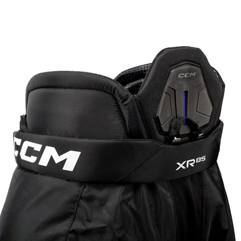 Close-up of a black CCM XR85 hockey pants leg guard with white CCM branding on the strap and leg protector.